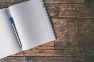 Open notebook and pen on a wooden table