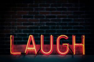 Neon sign reading "Laugh"